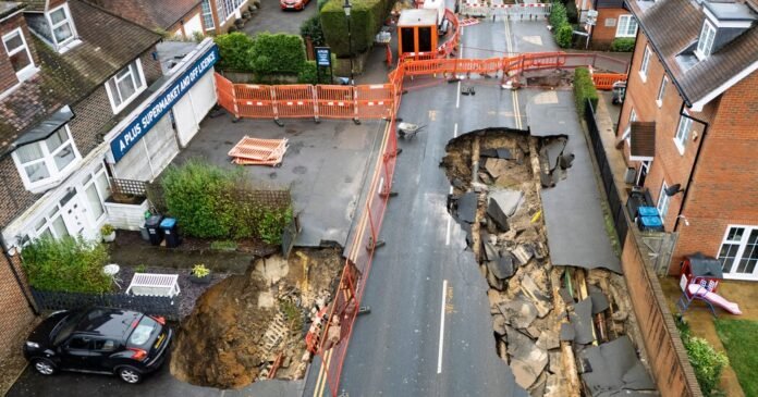 Grandes buracos se abrem em Surrey, Inglaterra; Os carros oscilantes no limite
