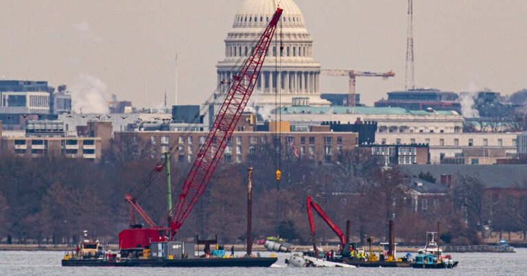 As equipes levantam os primeiros destroços do acidente de avião dc de Potomac
